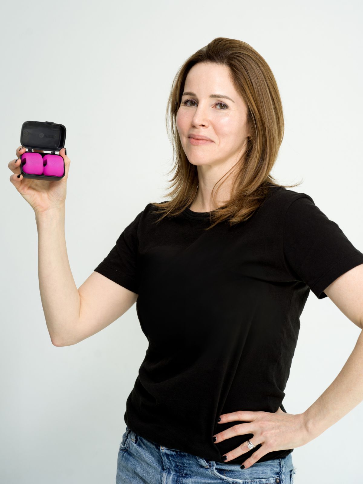 Susannah Sung, founder of FaceSculpter, smiling while holding the FaceSculpter facial sculpting device.